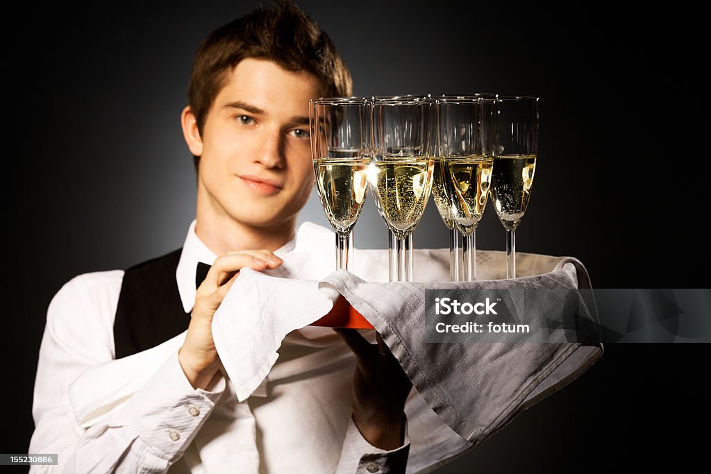 your order, please! professional waiter in uniform is serving wine Domed Tray Stock Photo