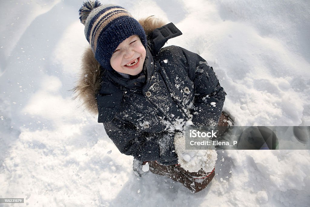 Boy in the winter. The boy sits in the snow and laughing. View from above. 6-7 Years Stock Photo