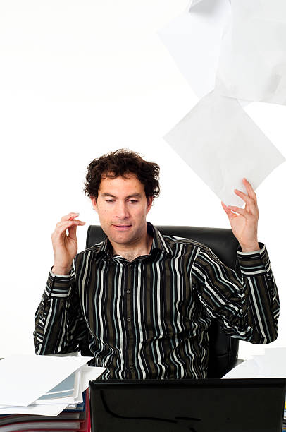 istock Man sitting at desk throwing up paperwork 155231589
