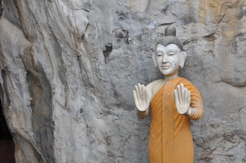 Standing buddha image on limestone background