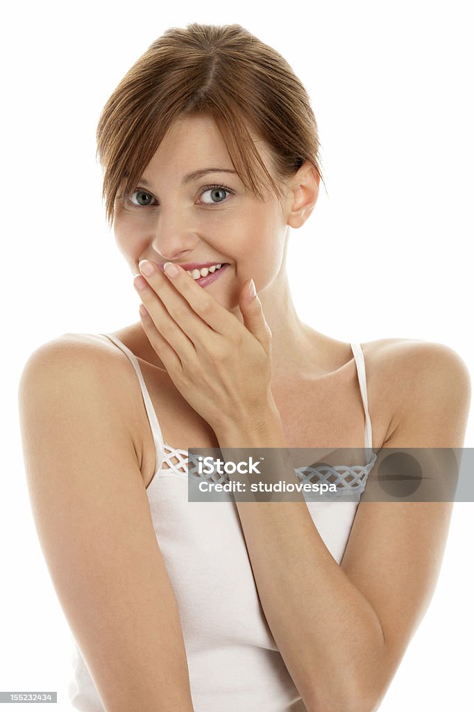 Giovane donna che copre la bocca con la mano mentre sorridente - Foto stock royalty-free di Donne