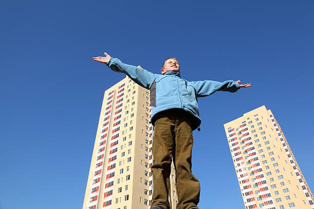 istock Little boy in blue jacket raises his arms 155232521