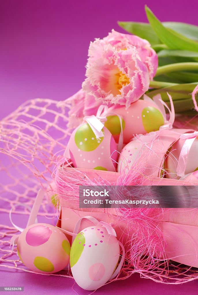 easter decoration pink tulips  and colored eggs in pink basket as easter decoration Basket Stock Photo