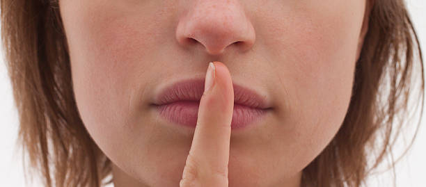 istock Young woman face making silence sign 155233485