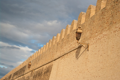 Ancient brick wall with mosque lanterns in Kairouan