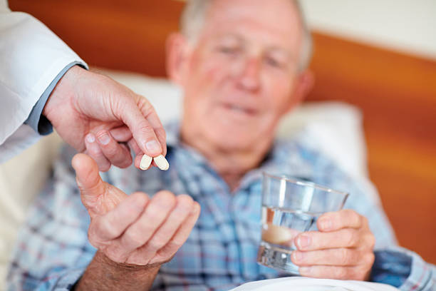 istock Senior man being given pills by doctor 155235813