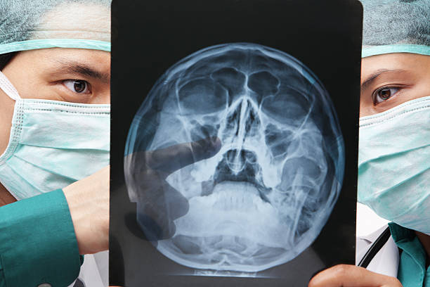 istock Two Asian surgeons discuss over skeleton roentgen 155235959