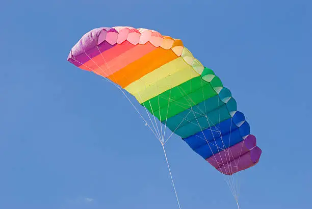 Colourful parafoilfoil stunt kite on a blue sky background.