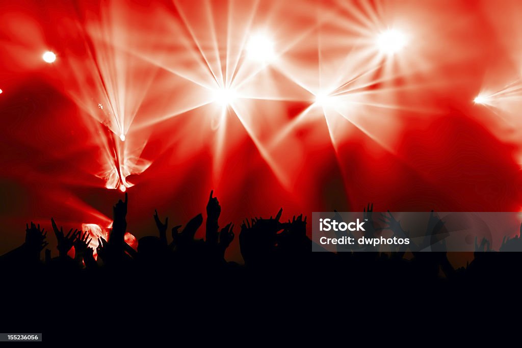 Multidão Aplaudindo o concerto com iluminação de fundo vermelho - Foto de stock de Ambiente - Evento royalty-free