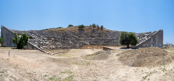 Panoramic view of the ancient amphitheater in the ancient city of Letoon. Letoon was the religious centre of Xanthos and the Lycian League. Mugla, Turkey - July 10, 2023.