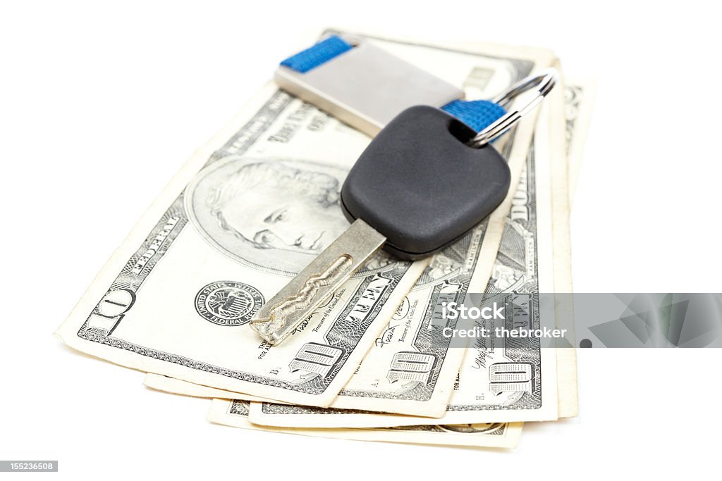 Car key and money Car key and dollar bills on white background with shallow depth of field Currency Stock Photo