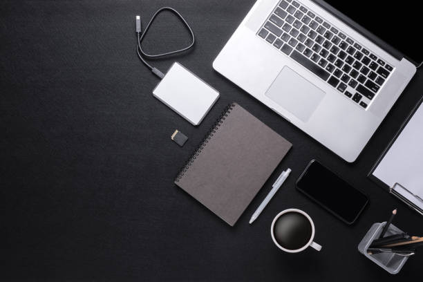 istock Black tone office desk with laptop, notebook, smartphone, clipboard, coffee cup 1552365794