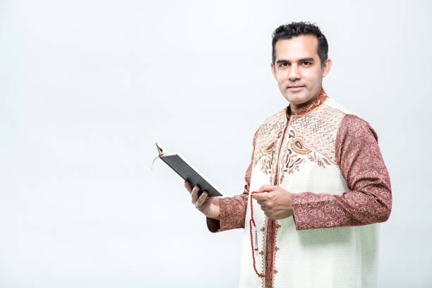 istock Asian Muslim man standing and reading the Quran 1552366825