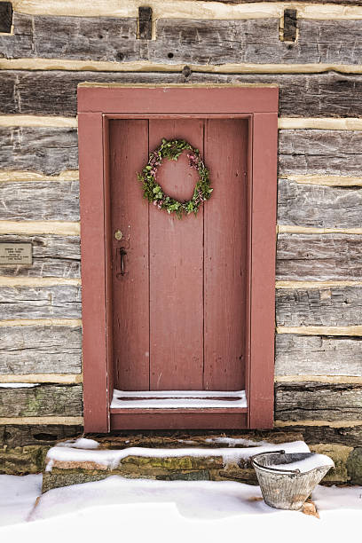 istock Christmas wreath on a log cabin door in snow 155238351
