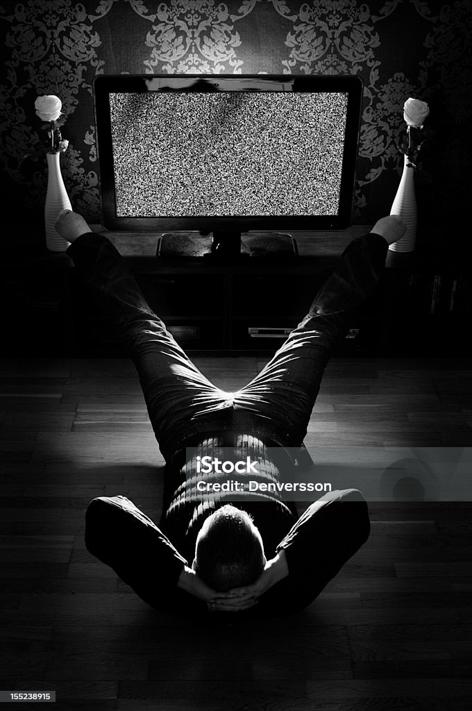 Guy Wathcing tv Uniqe shoot of a male laying on the floor watching tv with static , or you can replace it with your own screen picture.   Watching TV Stock Photo