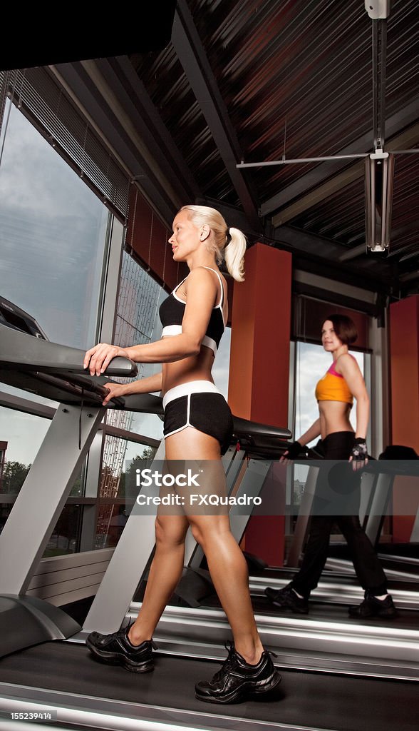 Dos atletas haciendo ejercicio en la cinta trotadora - Foto de stock de Actividad libre de derechos Dos atletas haciendo ejercicio en la cinta trotadora - Foto de stock de Actividad libre de derechos