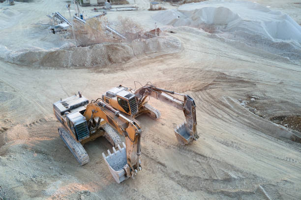 istock Open pit mining site of construction sand stone materials with excavator equipment for digging of gravel resources at quarry 1552395420