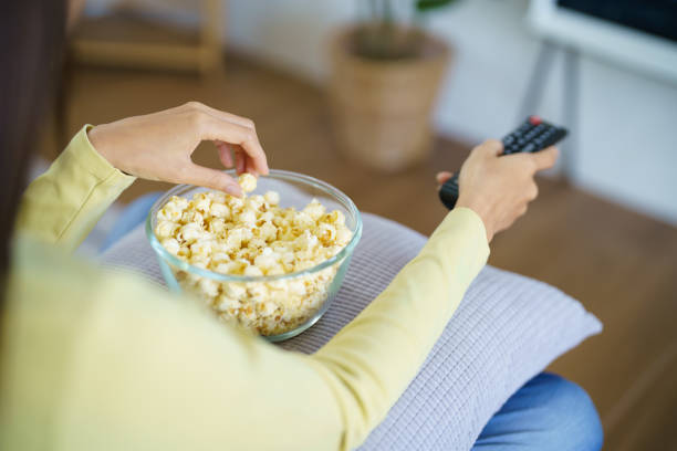 istock Asian woman Watching smart TV and using remote controller Hand holding television audio remote control at home with the remote control television 1552395618