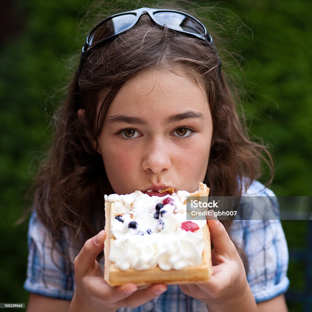 Girl eating waffle with cream and fruits Girl eating fruity cake Child Stock Photo