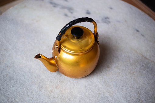 golden water pitcher isolated on gray background