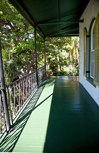 Balcony at Hemingway's house, Key West, Florida Second-floor covered balcony at Ernest Hemingway's house in Key West, Florida.  Image shows arched window with shutters and wrought-iron railing.  Architectural style is typical of older houses in Key West.   hemingway house stock pictures, royalty-free photos & images