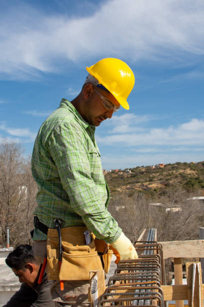 istock bricklayers with yellow helmet and protective glasses building an iron beam for reinforced concrete - PHOTO SESSION: WORK IN CONSTRUCTION 1552398976
