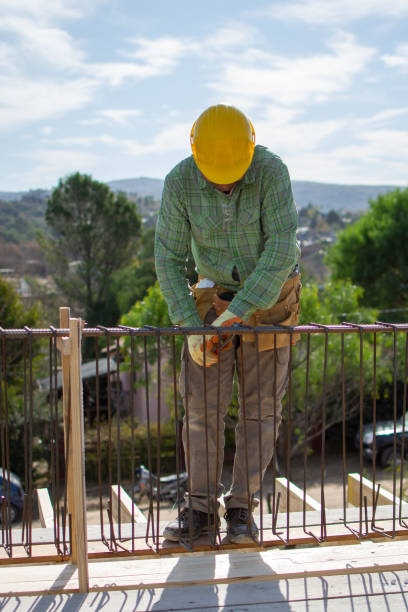 istock bricklayers with yellow helmet and protective glasses building an iron beam for reinforced concrete - PHOTO SESSION: WORK IN CONSTRUCTION 1552401495