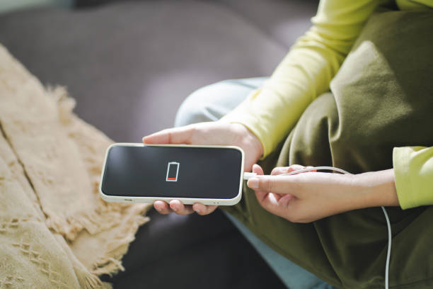 istock Woman hands Charging mobile phone battery with low battery. plugging a charger in a smart phone Â with energy bank powerbank power charger Modern lifestyle energy technology concept. 1552410273