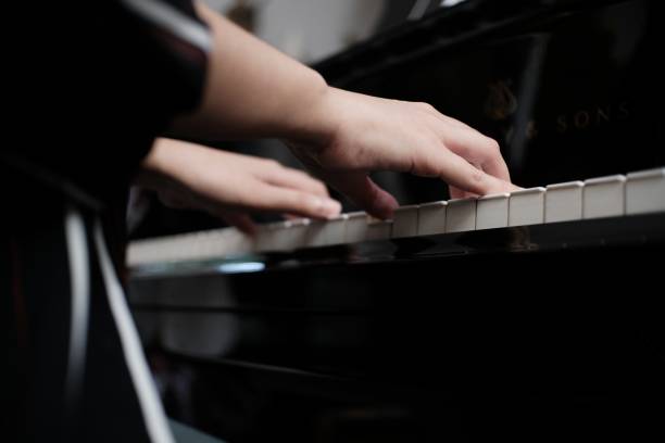 istock Beautiful woman playing piano, learn to play piano. 1552417285