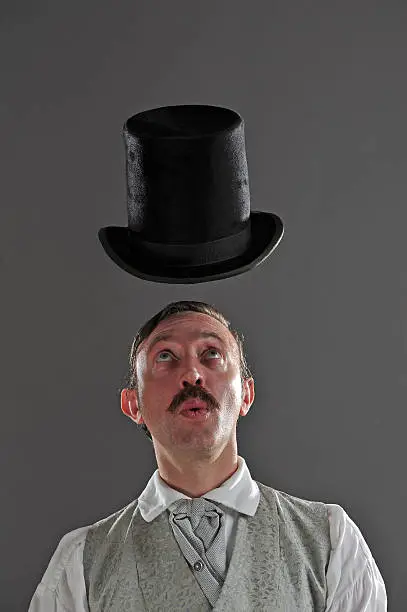 A Victorian gentleman raises his top hat without using his hands.