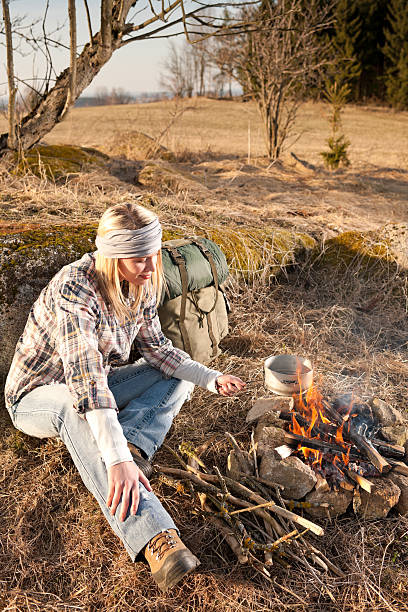 istock Hiking woman with backpack cook by campfire 155244192