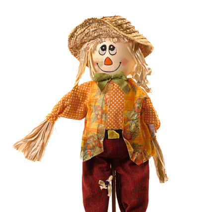 Straw and fabric scarecrow with smiling face for Halloween. Isolated on white background.