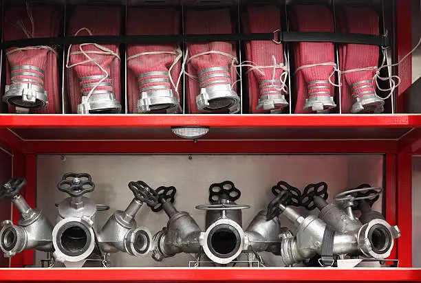 Fire cocks and hoses accurate organized inside big red fire engine
