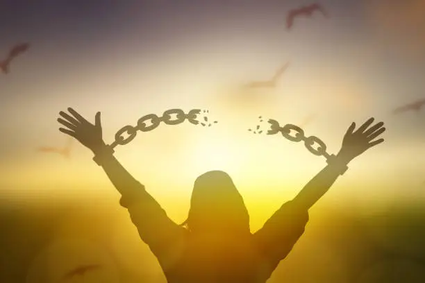 Photo of silhouette women hand up and broken chain and bird sunrise background .freedom concept
