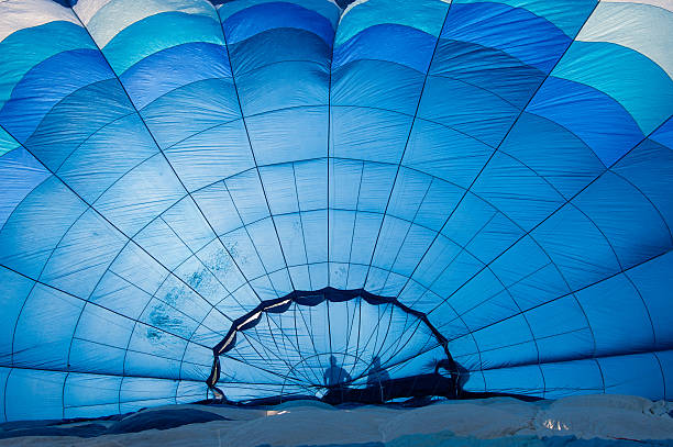 Goreme, Turkey - November 12, 2017: Two assistants fold the fabric of the hot air balloon that landed after the flight at a great tourist attraction of spectacular Cappadocia