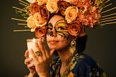 Portrait of a woman with sugar skull makeup. Catrina with butterfly painted on her face. Halloween and day of the dead makeup.
