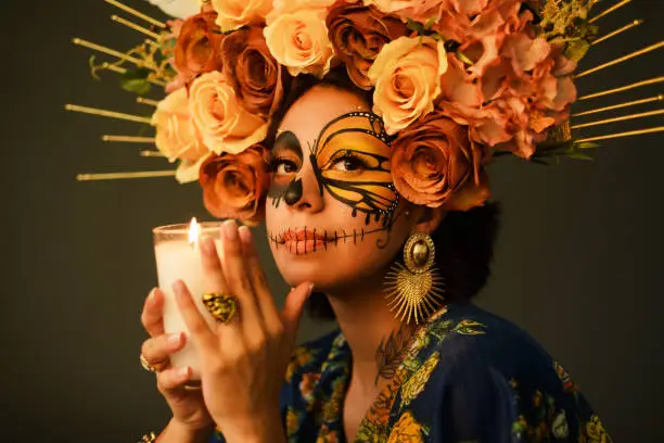 Portrait of a woman with sugar skull makeup. Day of the dead and halloween character with dark background.