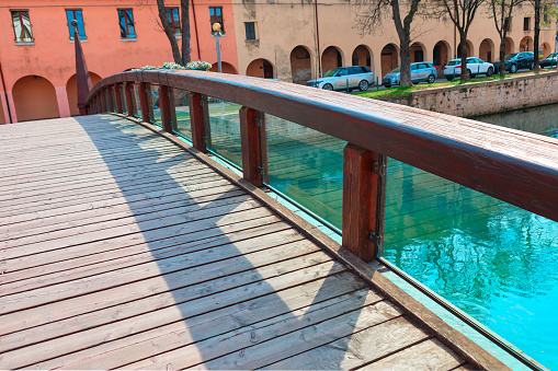 Wooden bridge with glass balustrade over the river in Treviso Italy