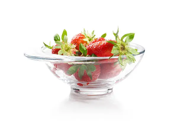 Tasty strawberries in a bowl isolated on white background.