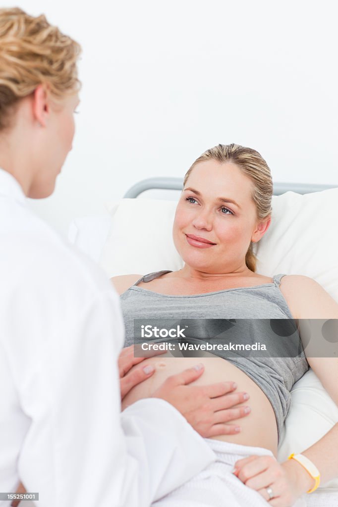 Nurse reassuring her pregnant patient Abdomen Stock Photo