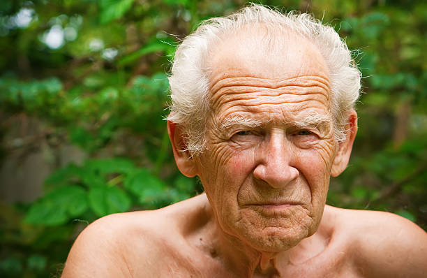 Senior man with serious look posing with crossing hands inside. Angry grandpa portrait.