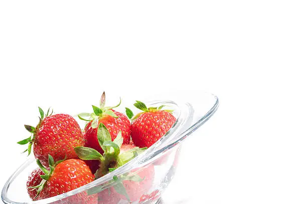 Tasty strawberries in a bowl on white background