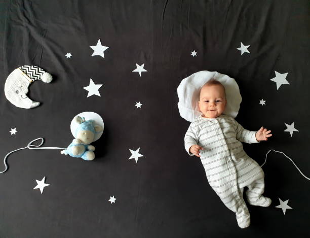istock Baby boy lying on bed and posing as an astronaut 1552531803