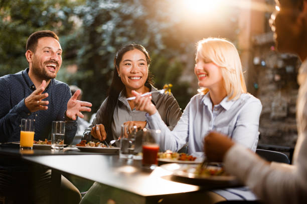 istock Group of happy colleagues talking while enjoying in lunch at a restaurant. 1552534449