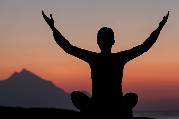 istock Woman meditating on sunrise 155253641