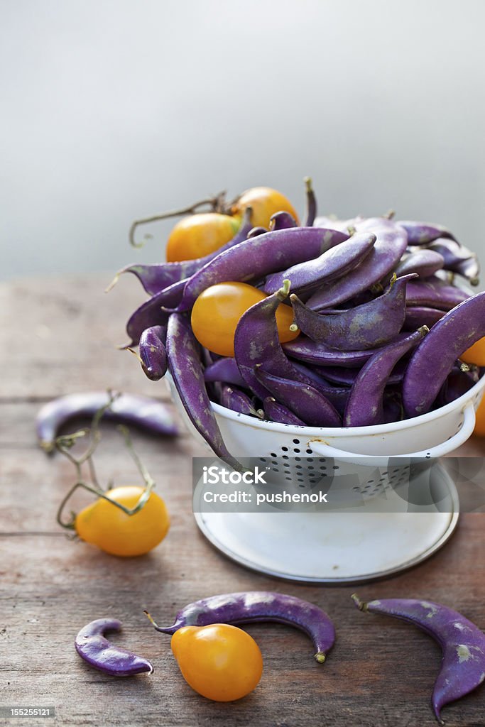 Des haricots violet et jaune de tomates dans le white colander - Photo de Agriculture libre de droits