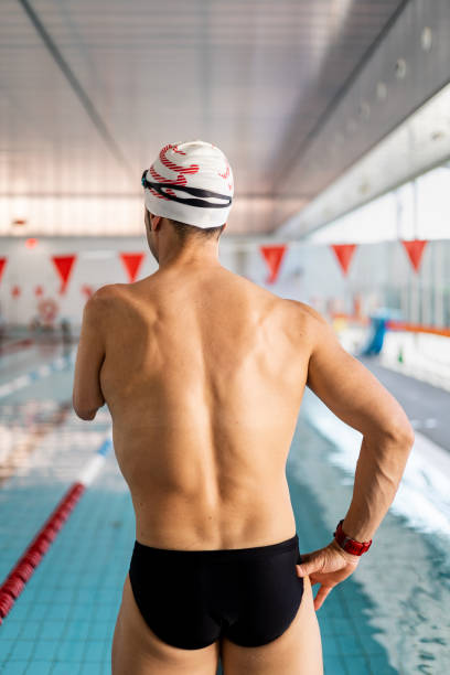 istock An unrecognizable swimmer with an amputated arm is posing on his back in a heated indoor pool. Concept of people with disabilities, athletes with an amputated arm, swimming for the disabled. 1552553617