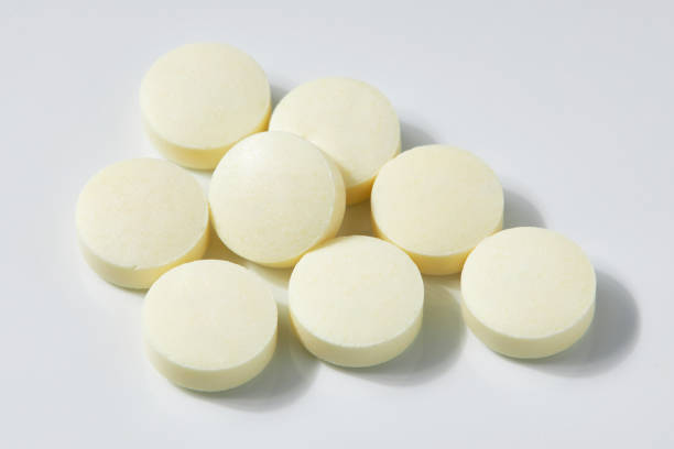 istock Top view of Many Circle-shaped yellow pills isolated on a white background. 1552557206