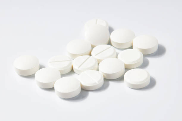 istock Many Circle-shaped white pills isolated on a white background. 1552557533