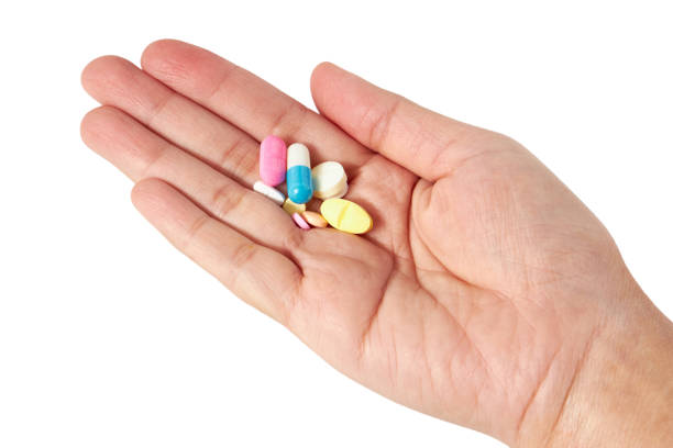 Hand holding A lot of pills different colors (white, pink, orange and blue color) and shapes isolated on a white background. Antipyretics, painkillers and antibiotics. Take medicine. Hand holding A lot of pills different colors (white, pink, orange and blue color) and shapes isolated on a white background. Antipyretics, painkillers and antibiotics. Take medicine. harakiri photos stock pictures, royalty-free photos & images